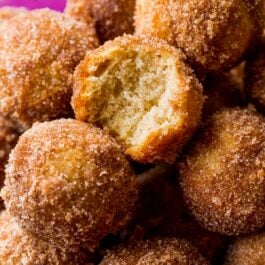 chai spice donut holes with a bite out of one showing the inside
