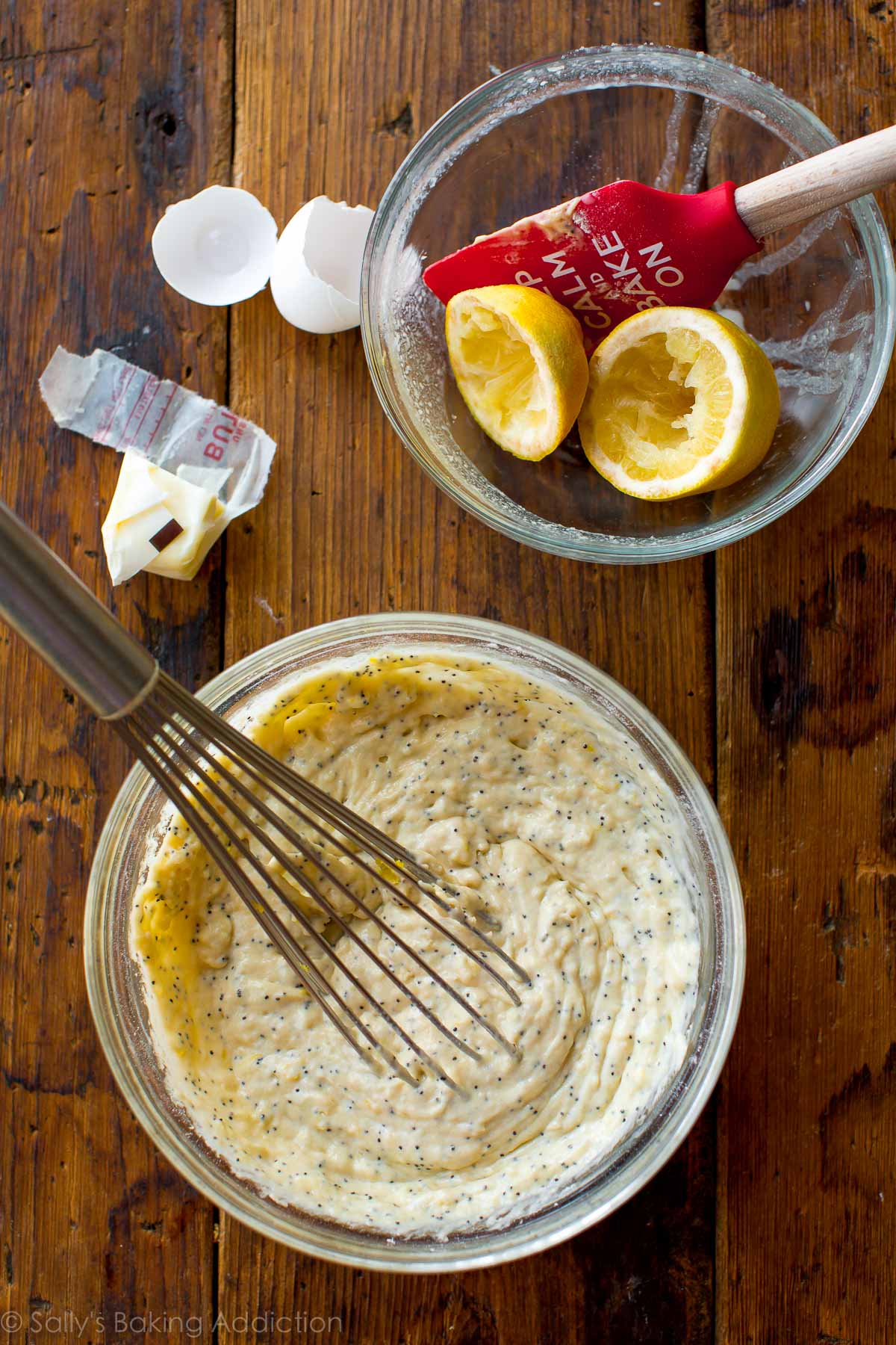 overhead image of lemon poppy seed donut batter in a glass bowl with a whisk