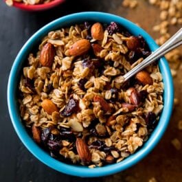 overhead image of maple almond cranberry granola in a blue bowl