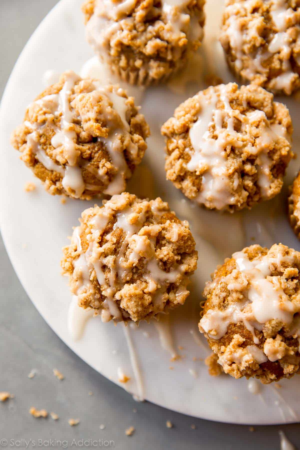 overhead image of pumpkin crumb cake muffins on a white plate