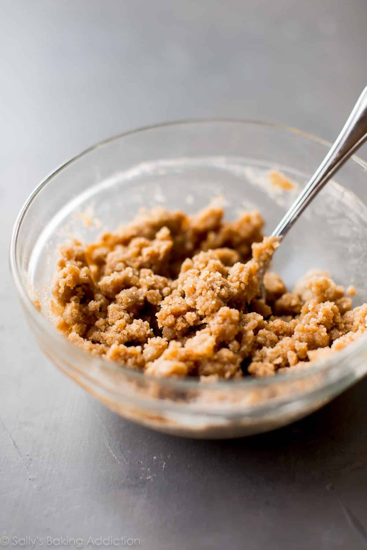 crumb cake topping in a glass bowl with a spoon