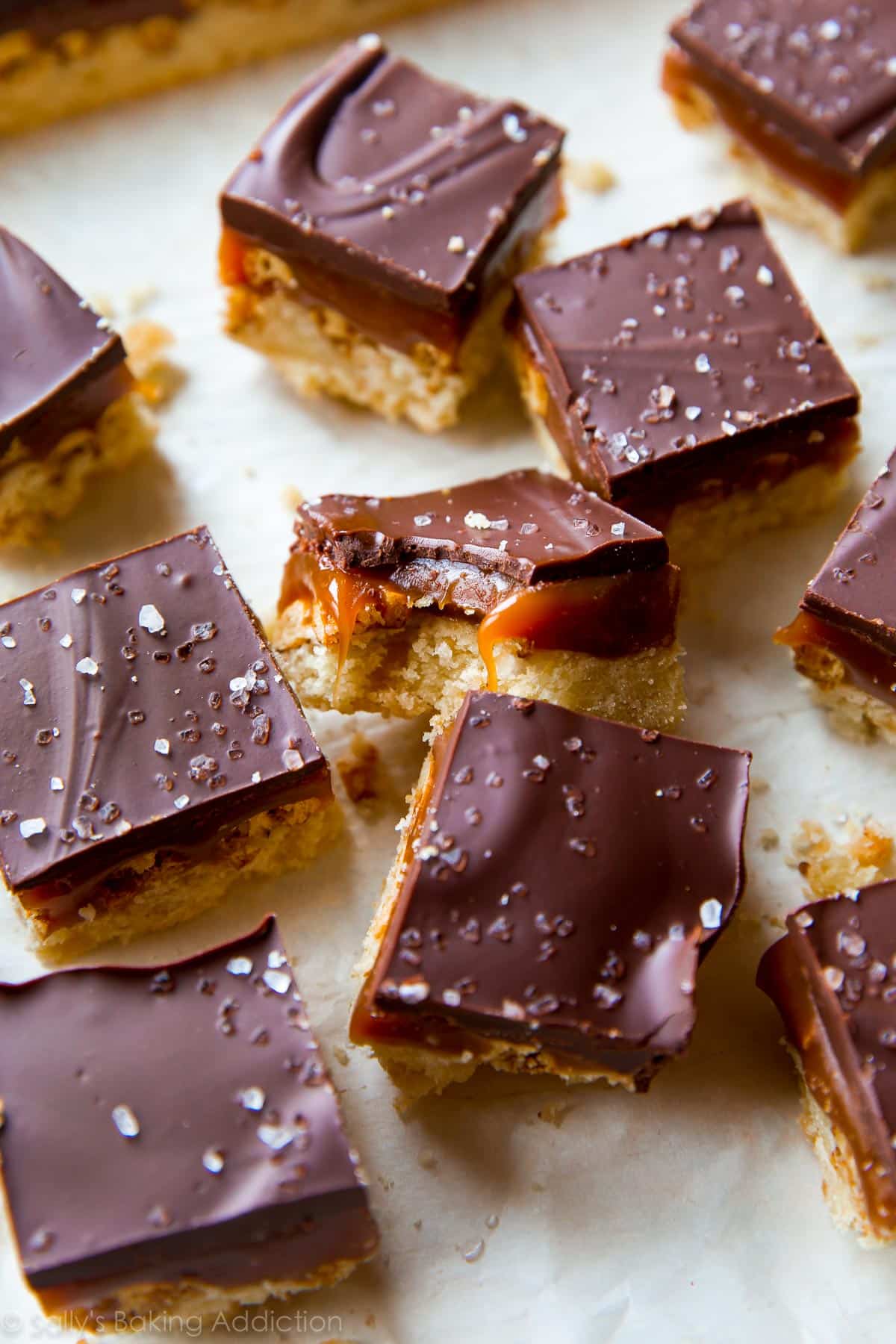salted caramel pretzel crunch bars cut into squares with a bite taken from one bar