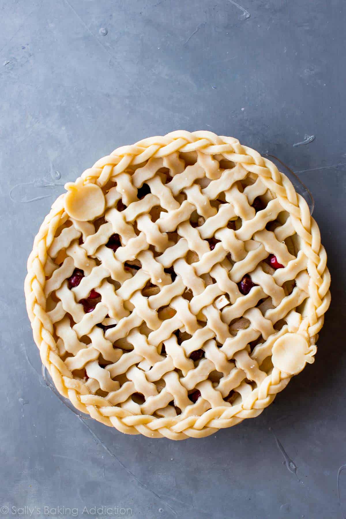 overhead image of apple cranberry pie with a lattice pie dough topping before baking