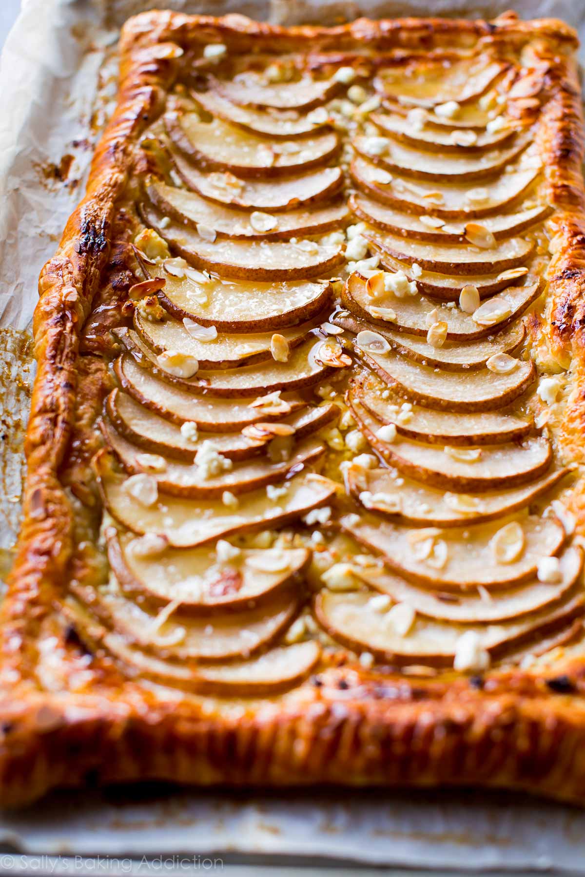 honey pear tart on a parchment paper lined baking sheet after baking