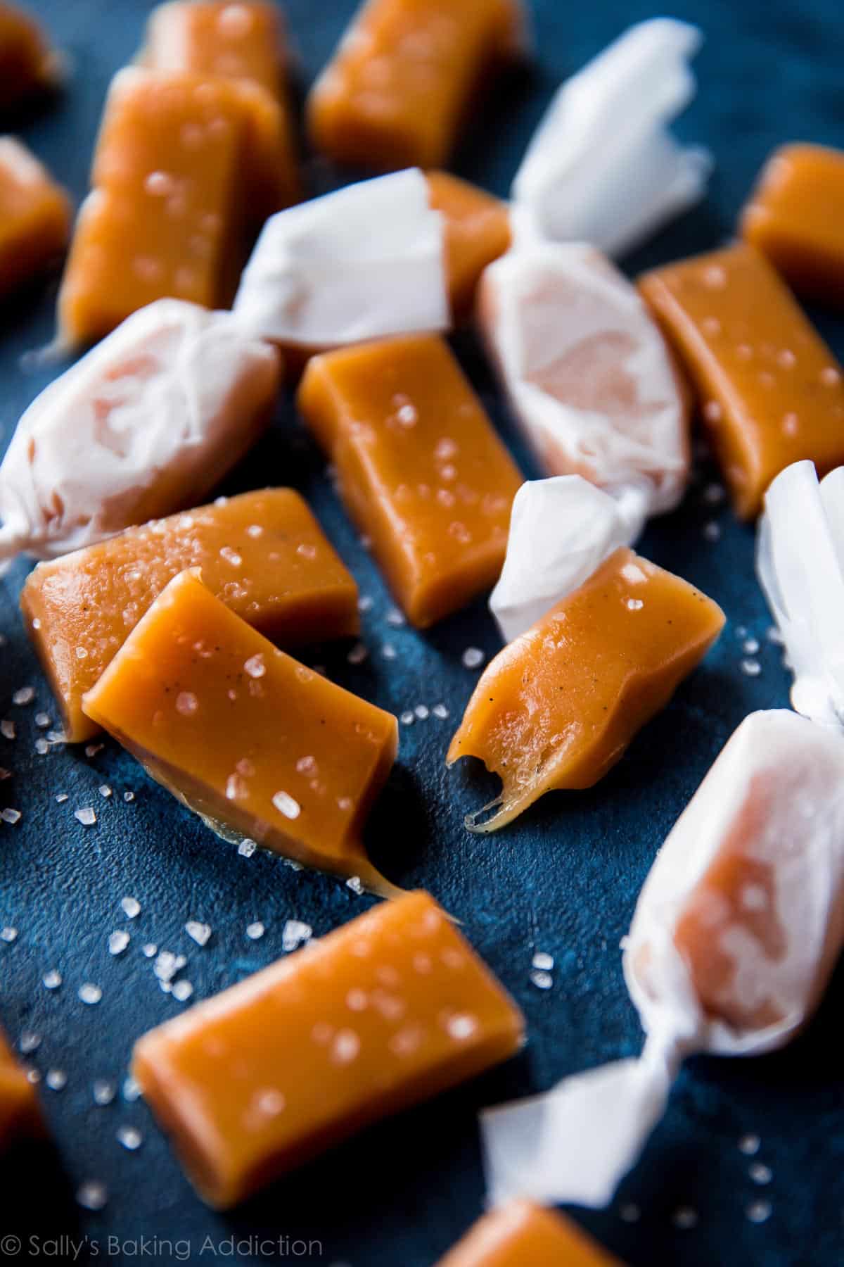 sea salt vanilla caramels cut into small rectangles with some wrapped in candy wrappers