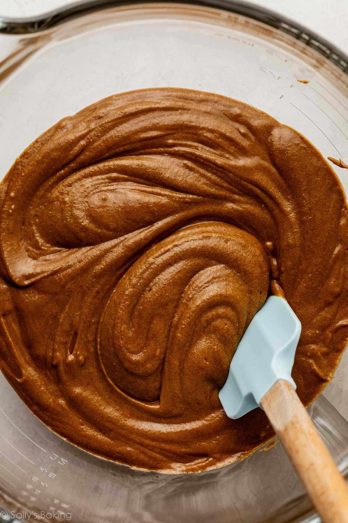 gingerbread batter in glass bowl with blue spatula.