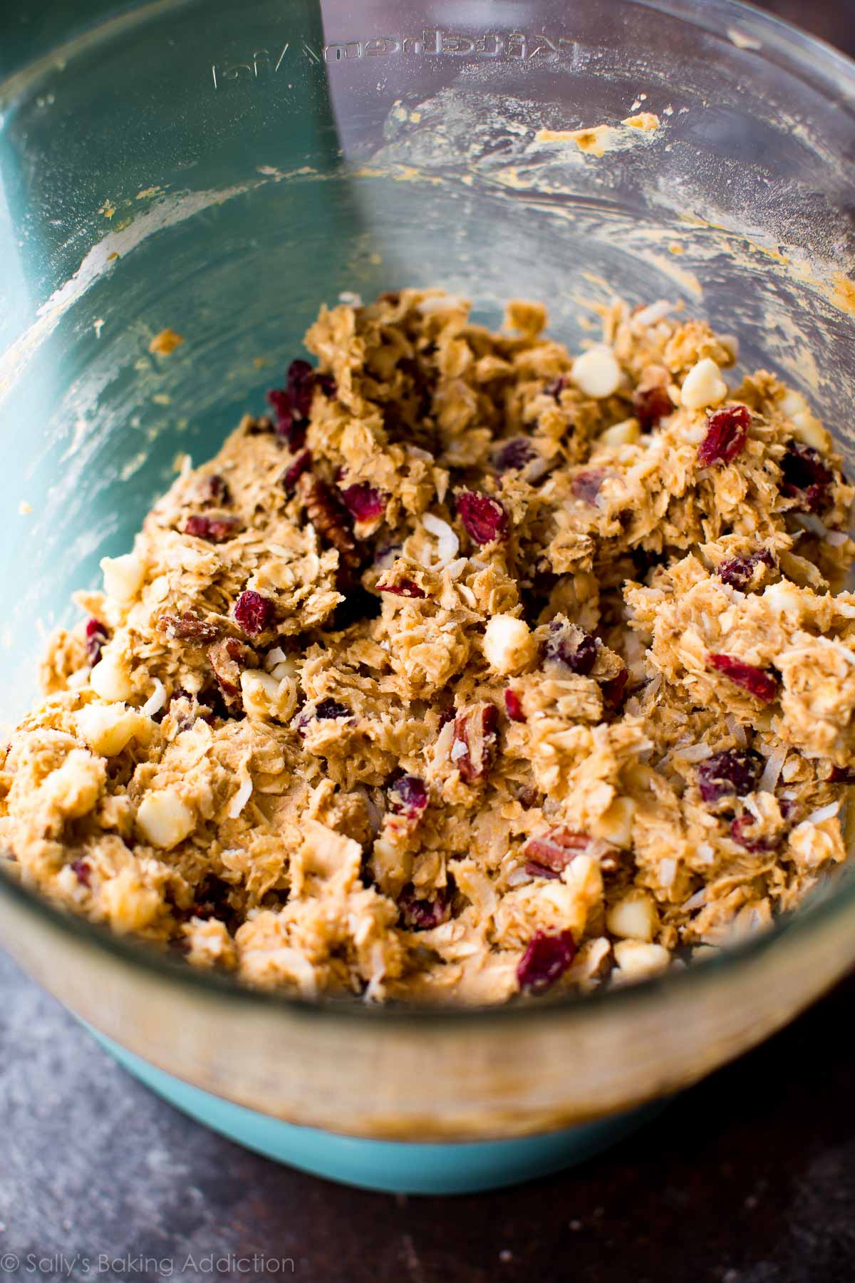 white chocolate cranberry coconut pecan oatmeal cookie dough in a glass bowl