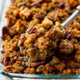 cornbread stuffing in a glass baking dish with a serving spoon