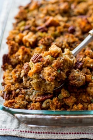 cornbread stuffing in a glass baking dish with a serving spoon