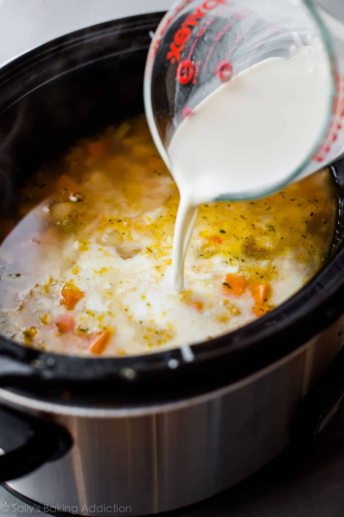 pouring milk into slow cooker for chicken corn chowder
