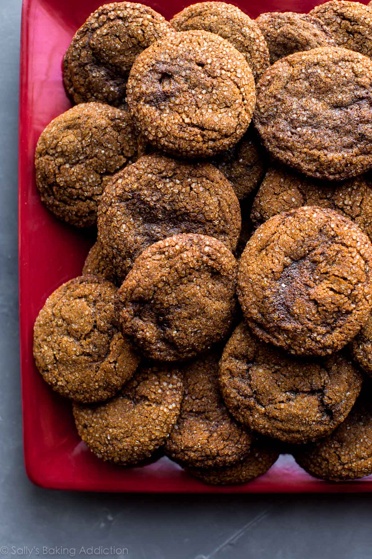overhead image of crisp molasses cookies on a red serving tray