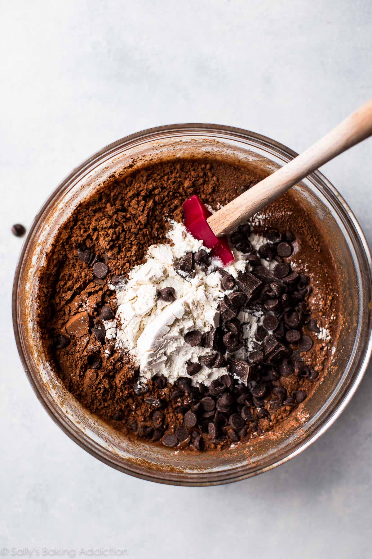 dry ingredients for brownies in a glass bowl with a spatula