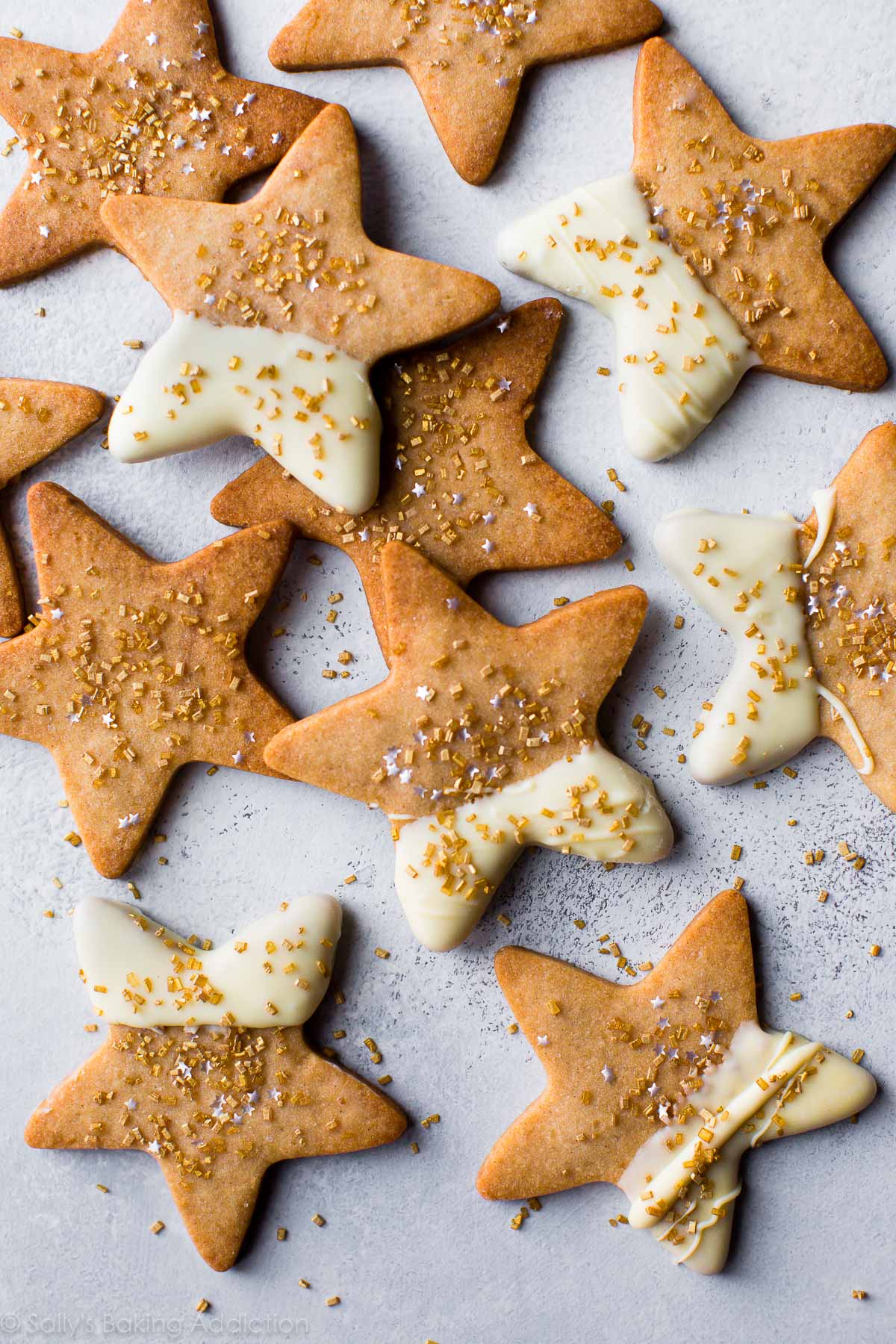 star shaped maple sugar cookies with half of each cookie dipped into white chocolate and topped with sprinkles
