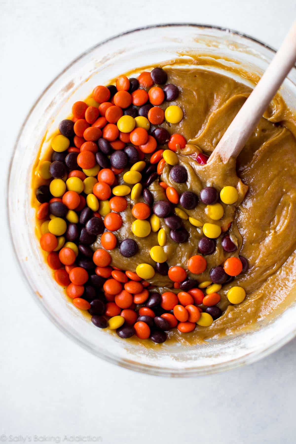 peanut butter blondie batter in a glass bowl with Reese's Pieces