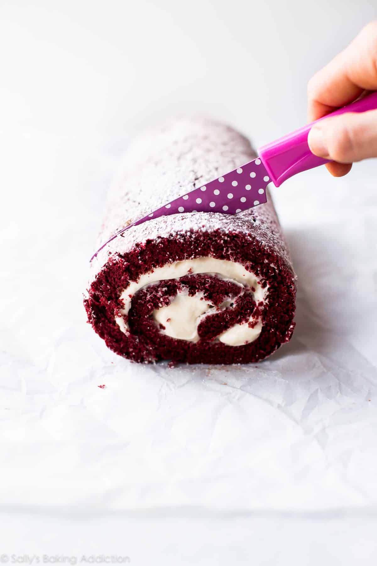 slicing red velvet cake roll