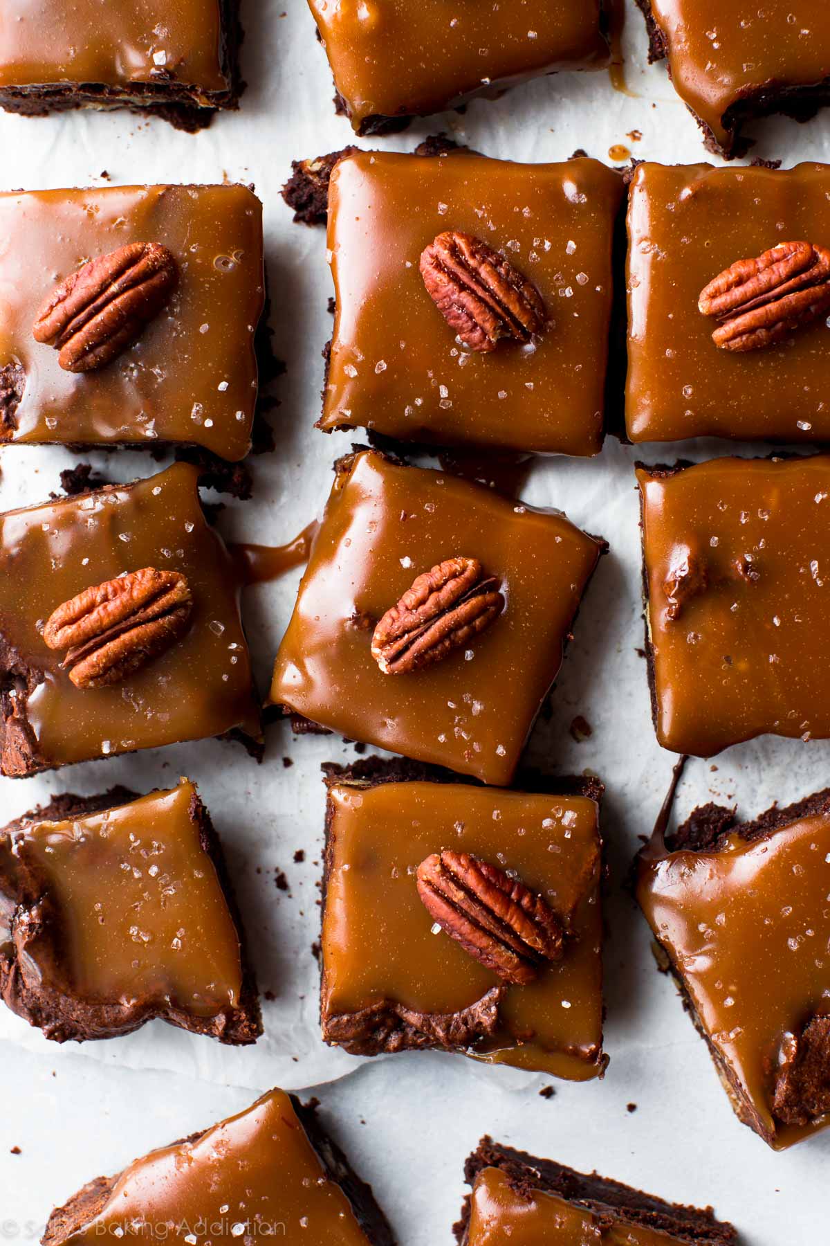overhead image of salted caramel turtle brownies with a pecan on top of each brownie square