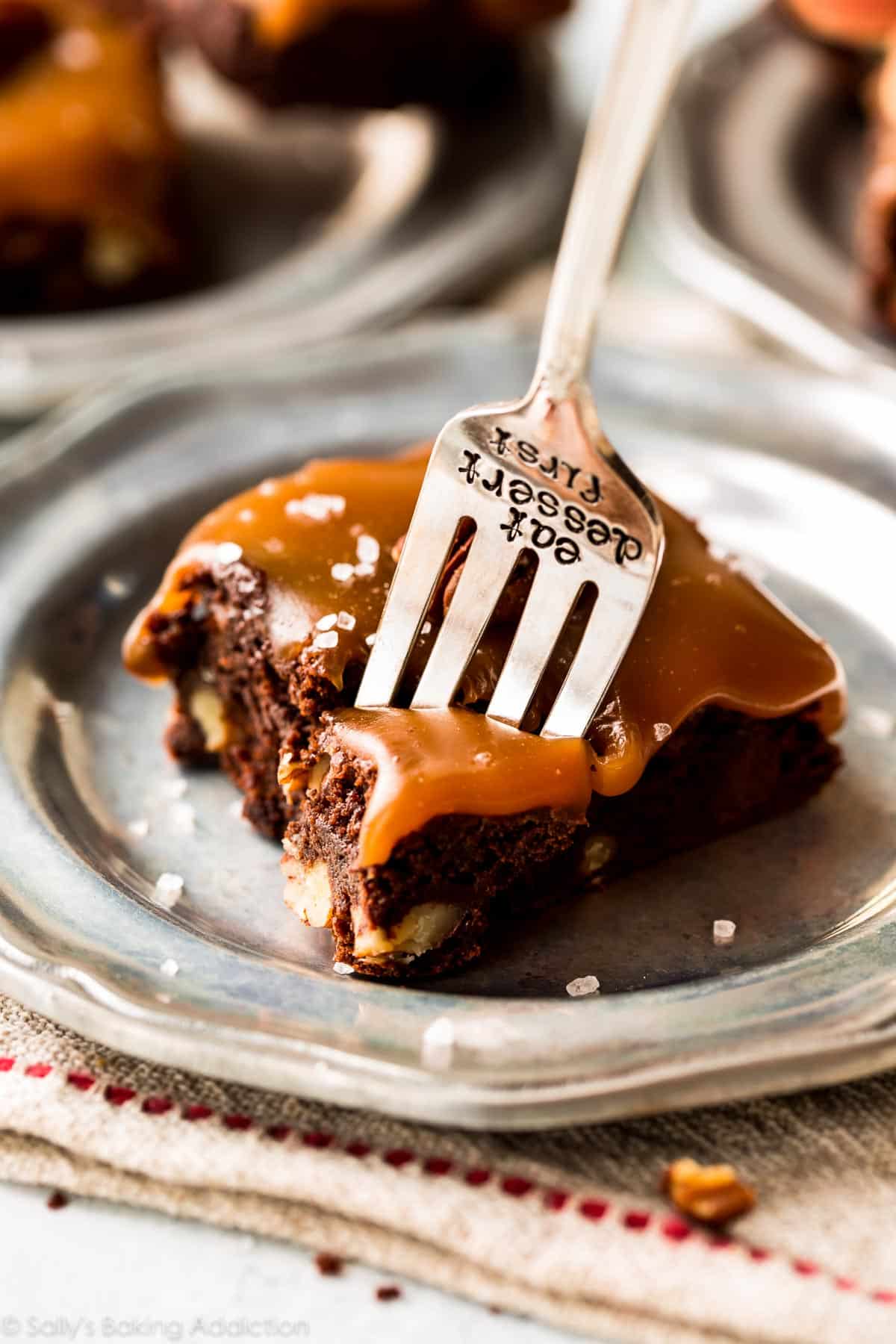 salted caramel turtle brownie on a silver plate with a fork