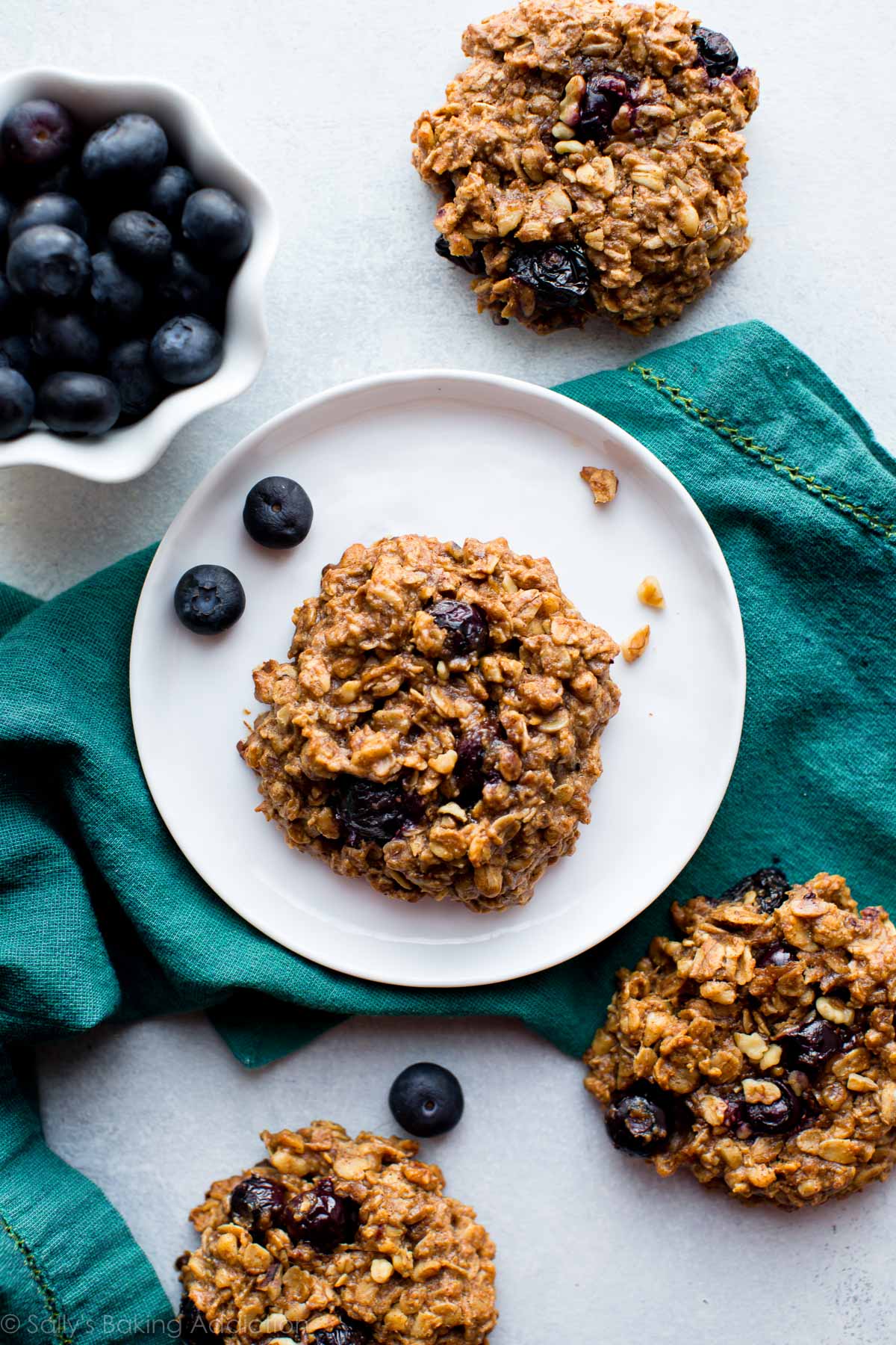 overhead image of blueberry breakfast cookies with one on a white plate