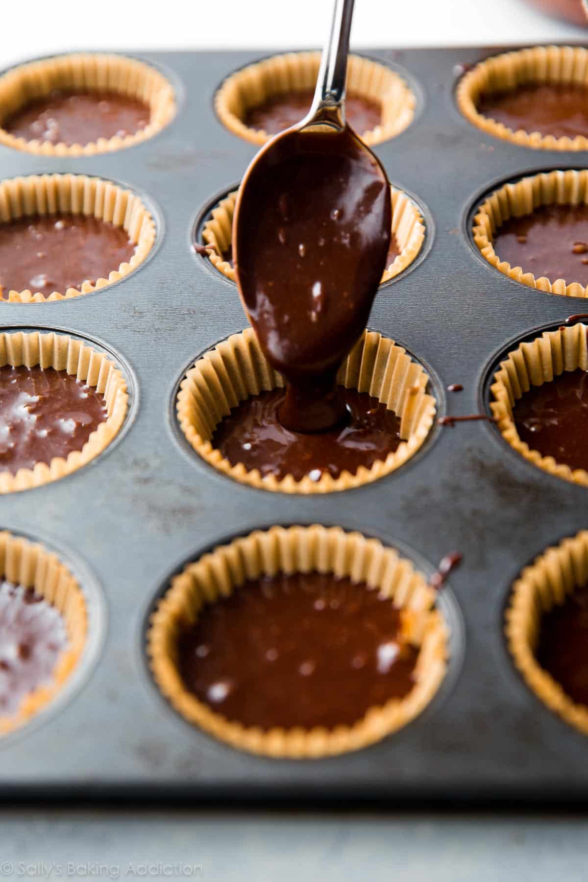 spooning chocolate cupcake batter into a cupcake pan