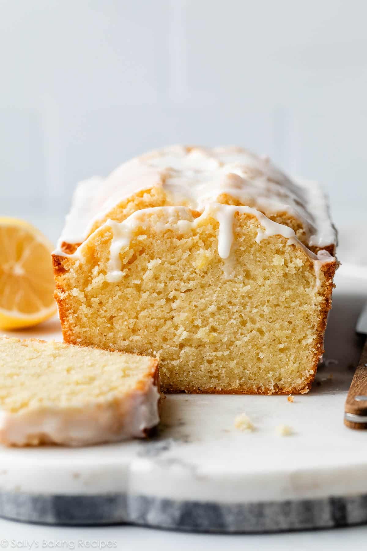 lemon pound cake sliced with icing dripping down in the front.