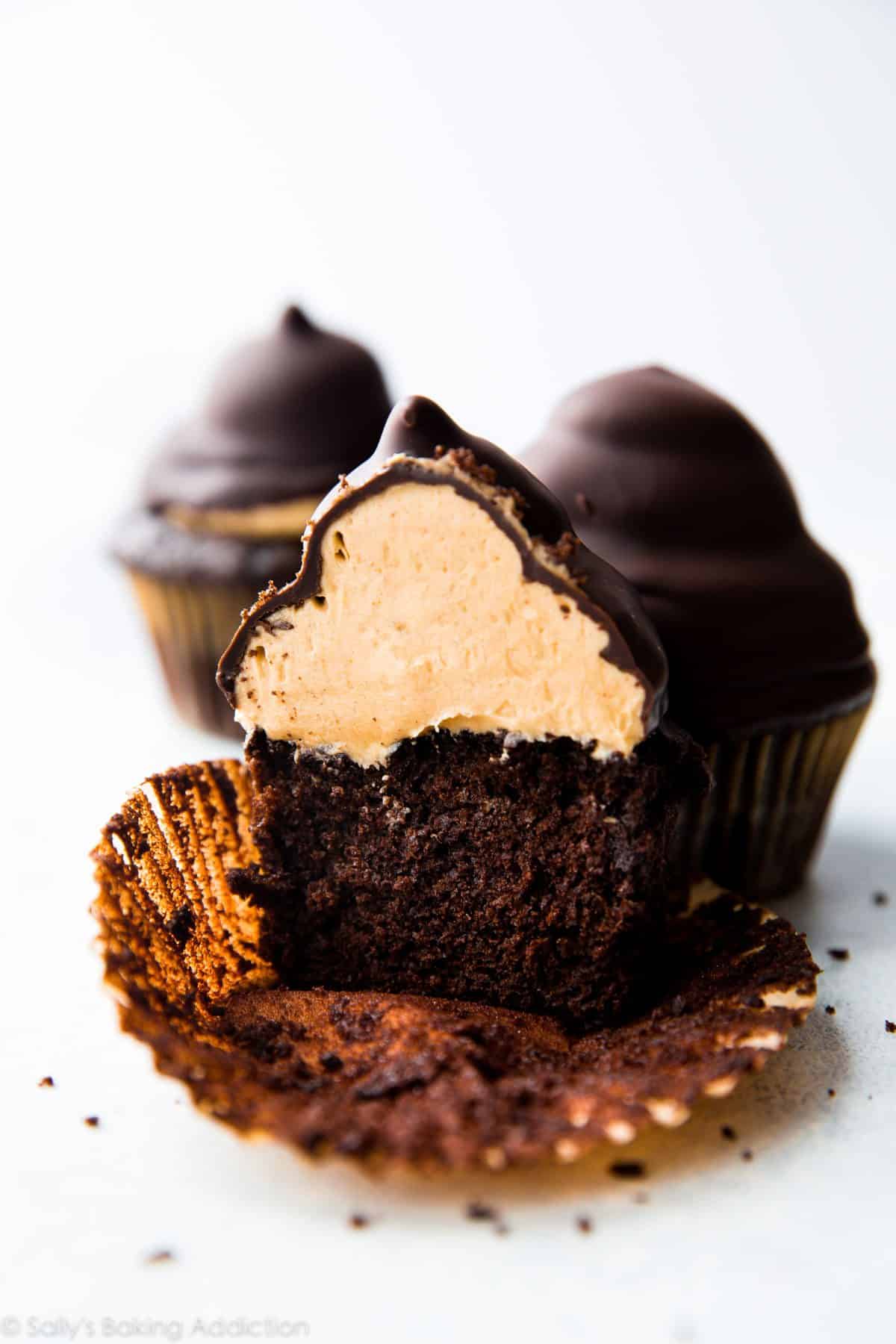 hi-hat cupcake cut in half showing chocolate cupcake topped with peanut butter frosting inside a chocolate coating