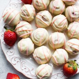 overhead image of strawberry cheesecake truffles on a white plate