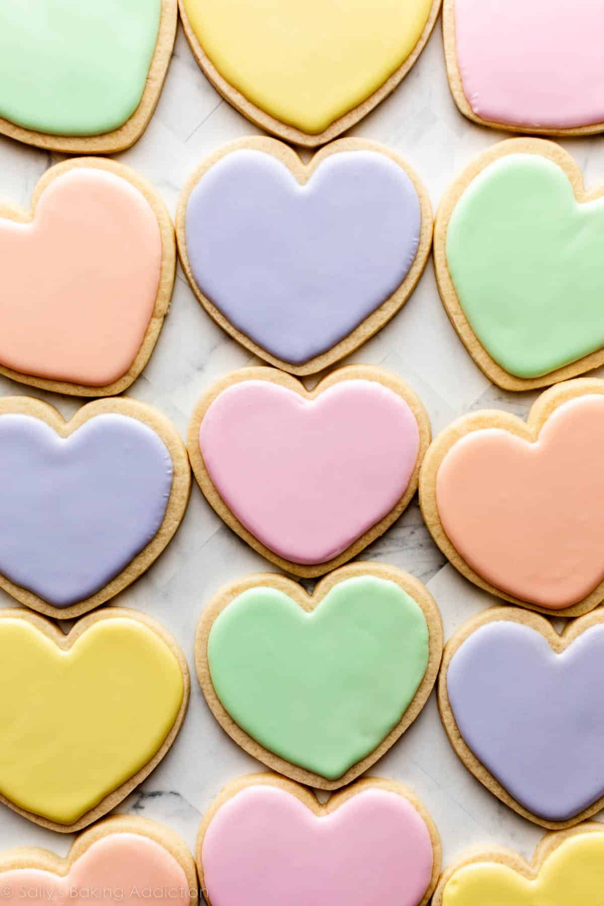 Valentine's Day heart sugar cookies decorated in pastel royal icing to look like conversation heart candies.