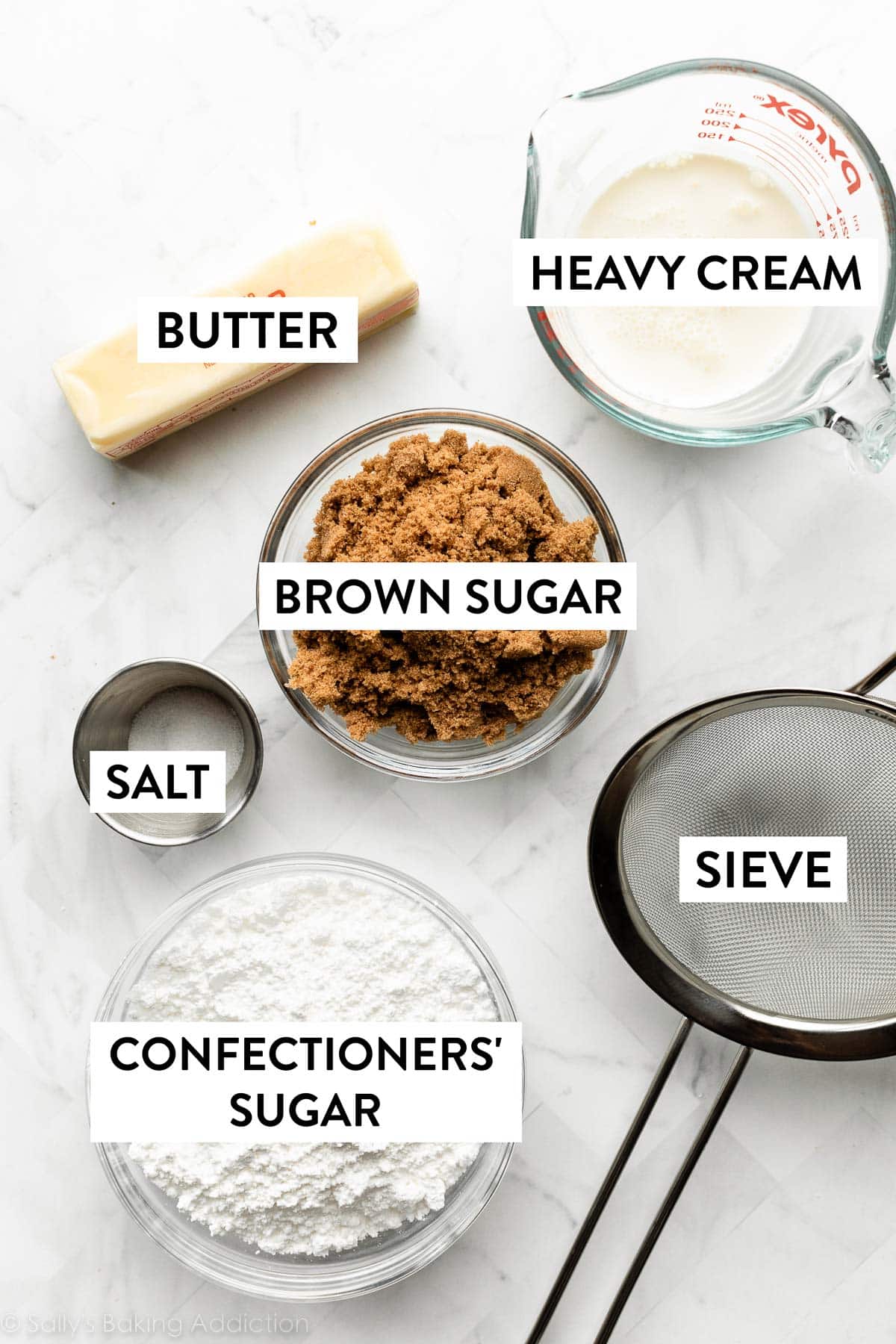 brown sugar, heavy cream, salt, confectioners' sugar, butter, and sieve on marble counter.