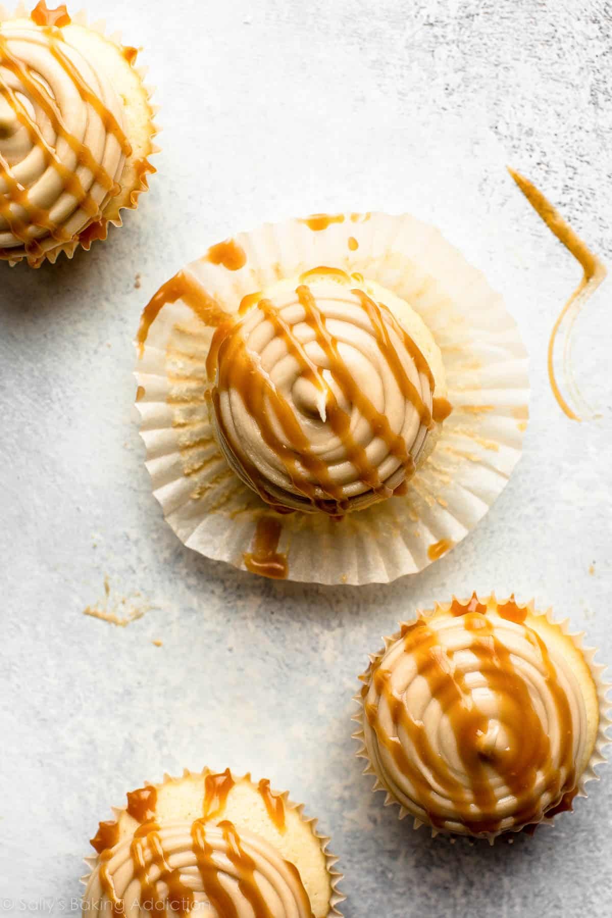 overhead shot of caramel frosted cupcakes with caramel sauce drizzled on top.