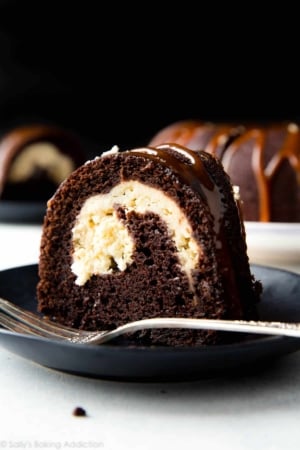 slice of chocolate cream cheese bundt cake on a black plate with a fork