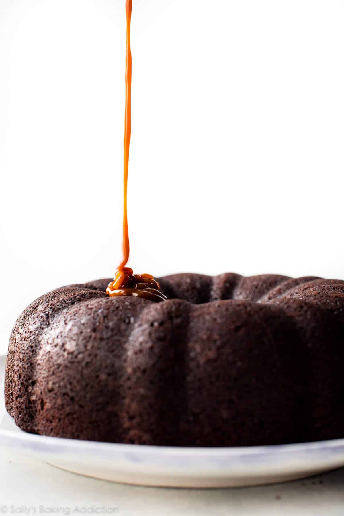 drizzling salted caramel onto chocolate bundt cake