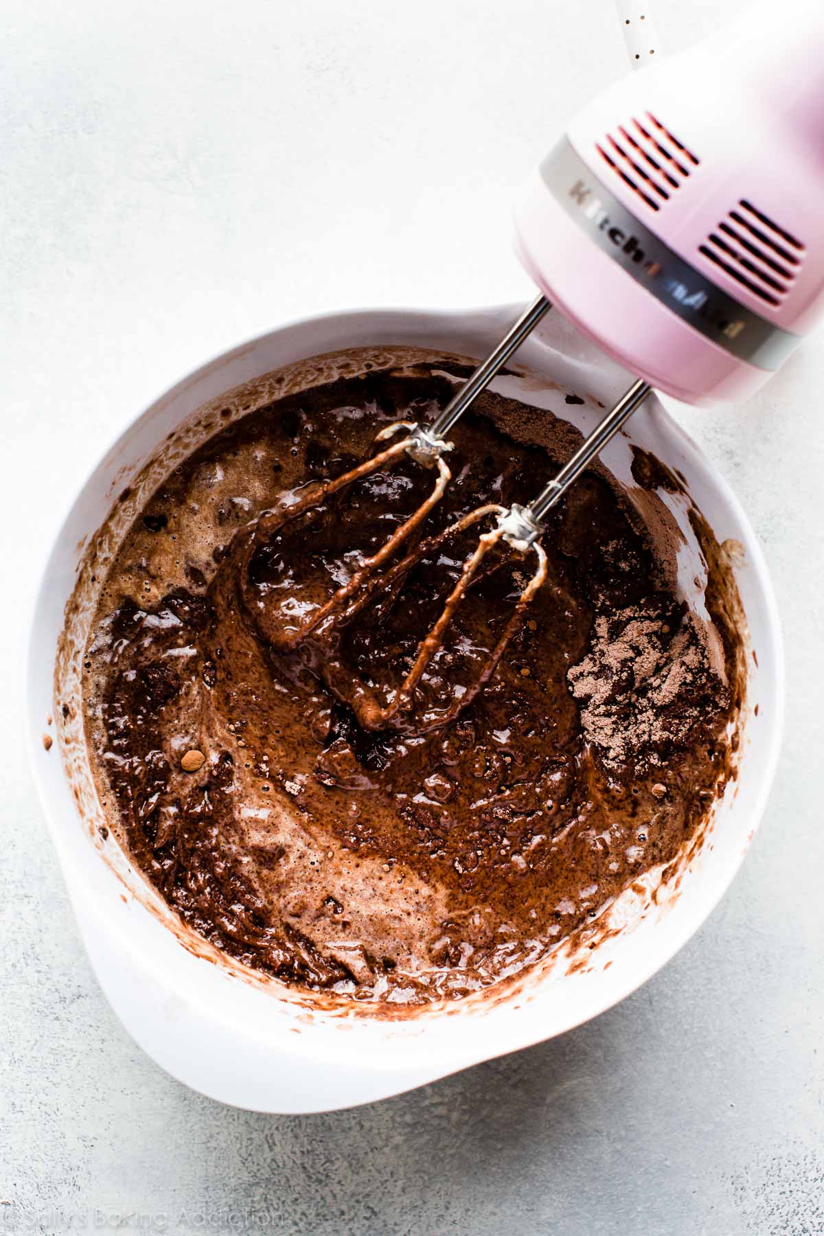 chocolate cake batter in a white bowl with a hand mixer