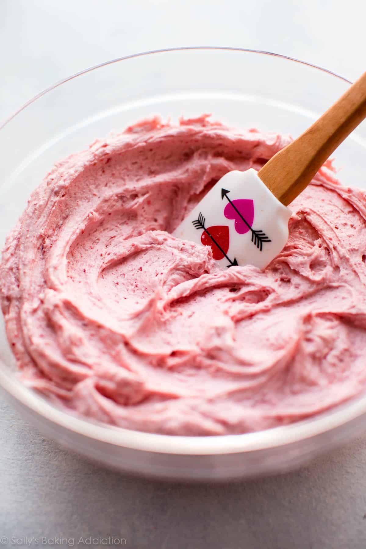 strawberry frosting in a glass bowl with a spatula