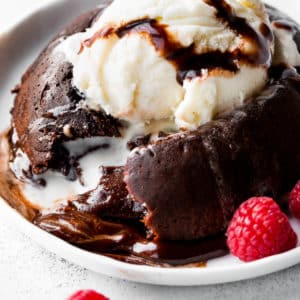 chocolate lava cake with a scoop of vanilla ice cream on a white plate.