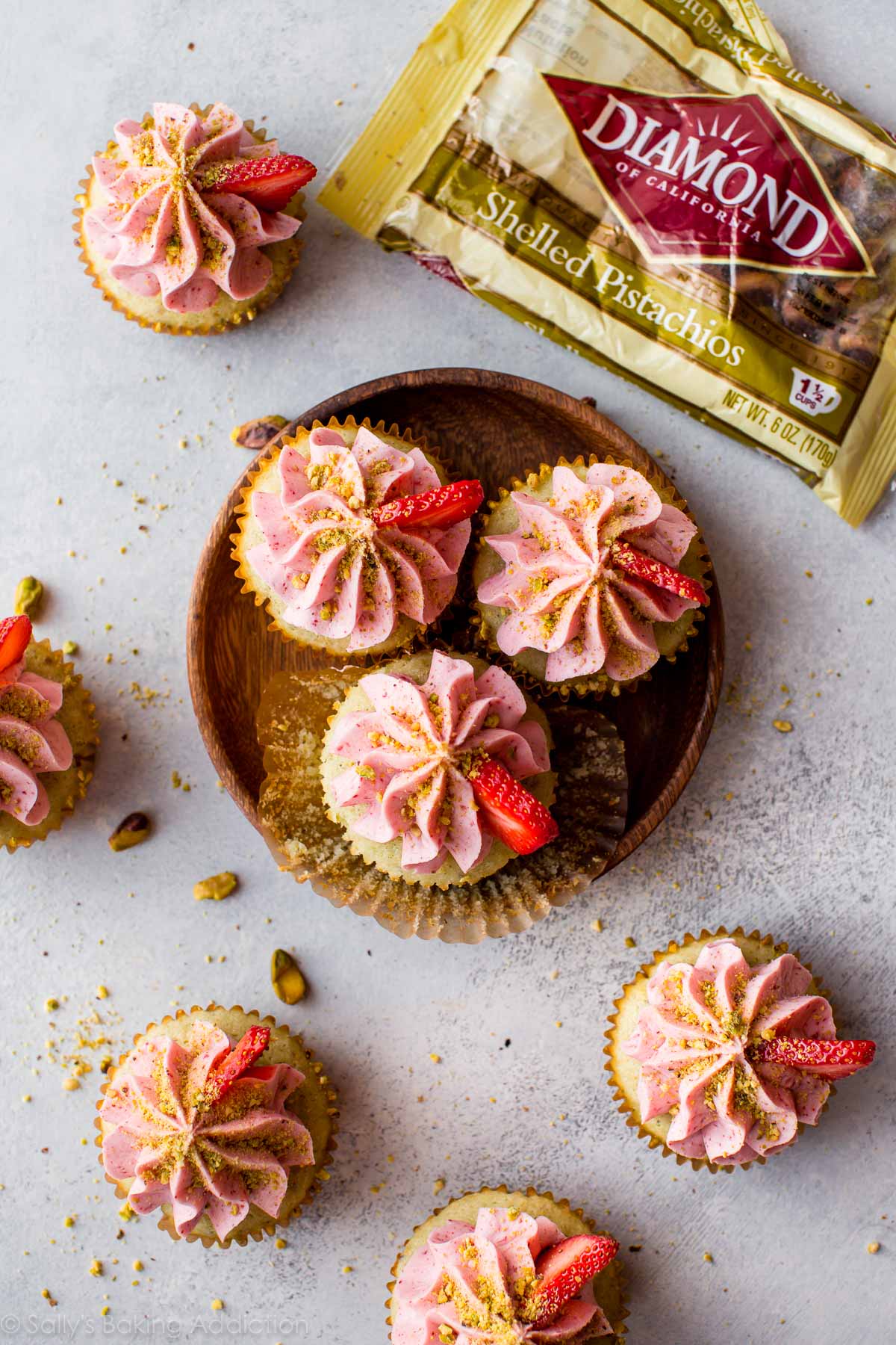 overhead image of pistachio cupcakes topped with strawberry frosting
