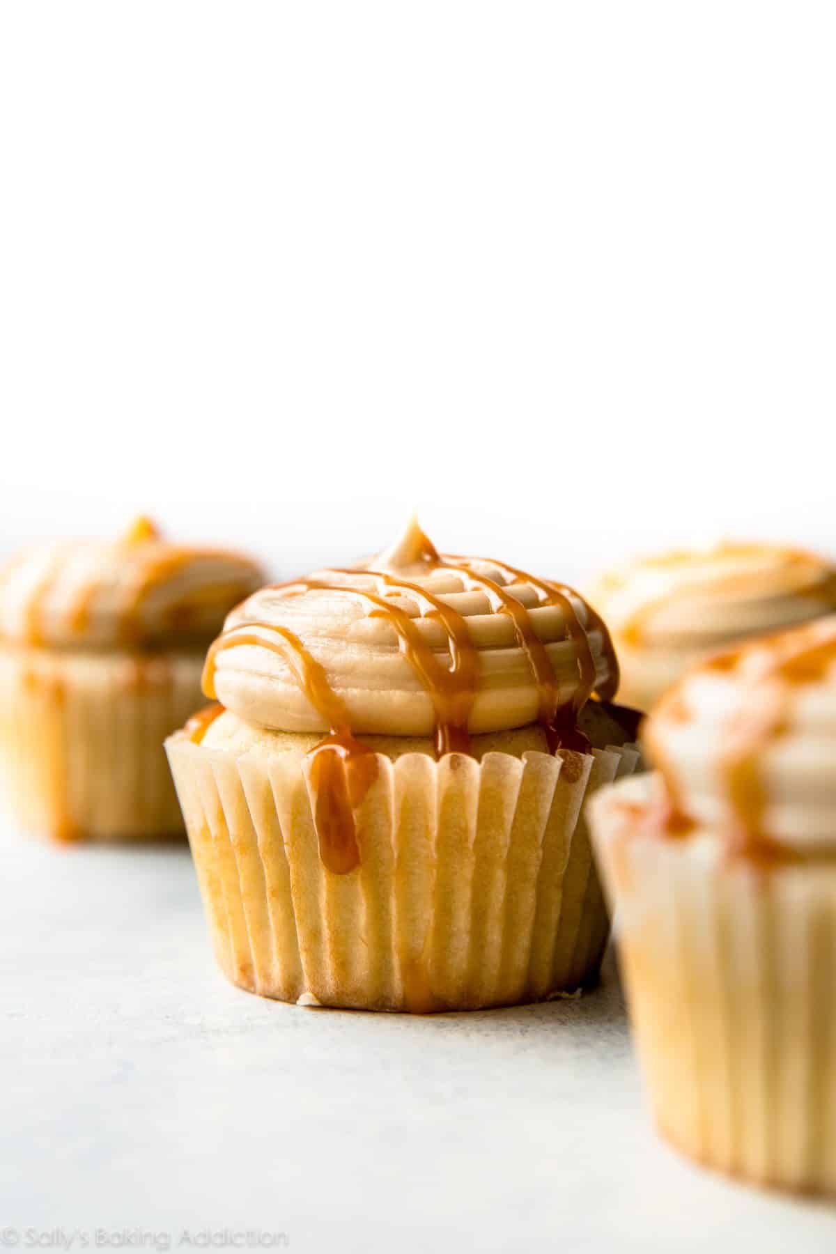 cupcakes topped with salted caramel frosting and a drizzle of salted caramel