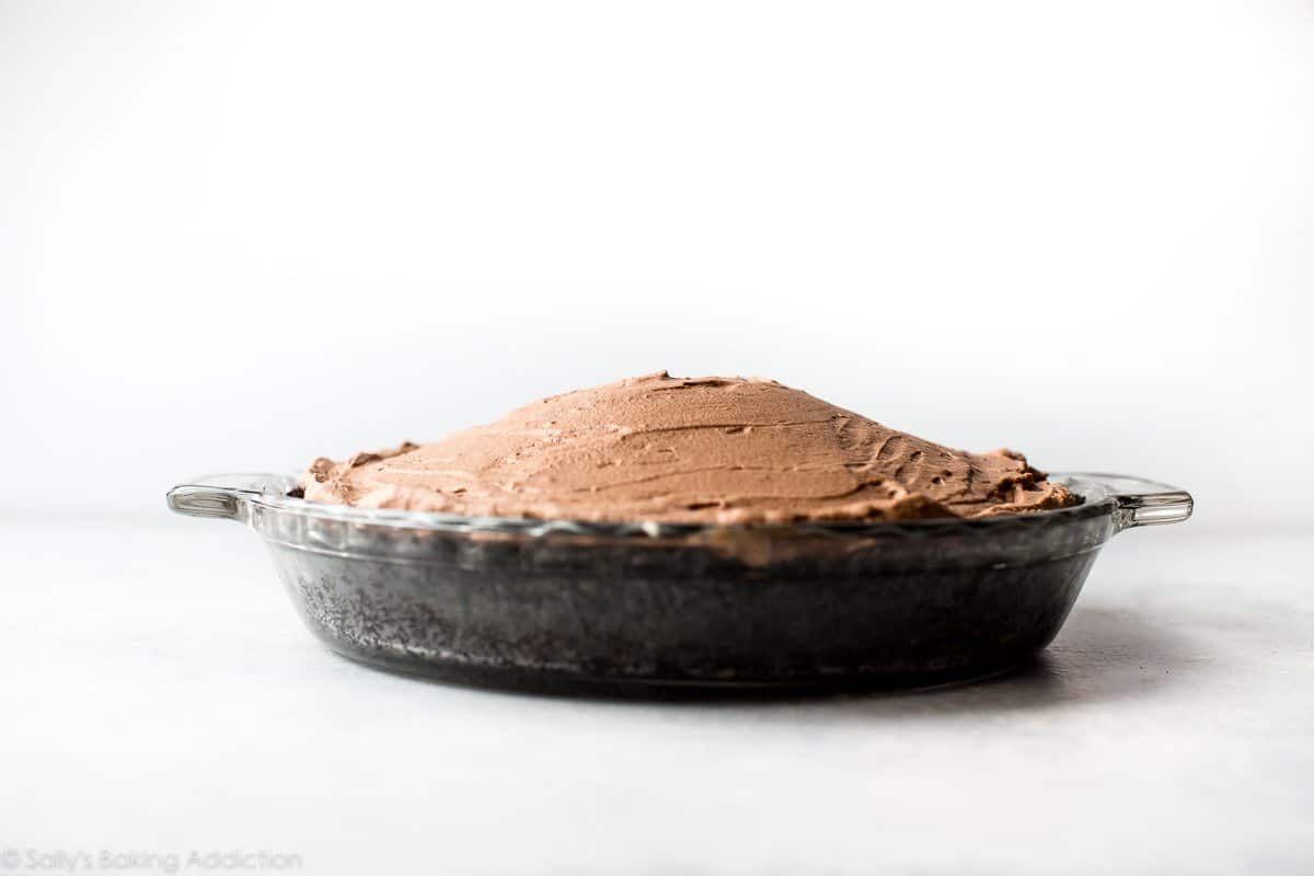 domed chocolate mousse on top of Oreo crust in a glass baking dish