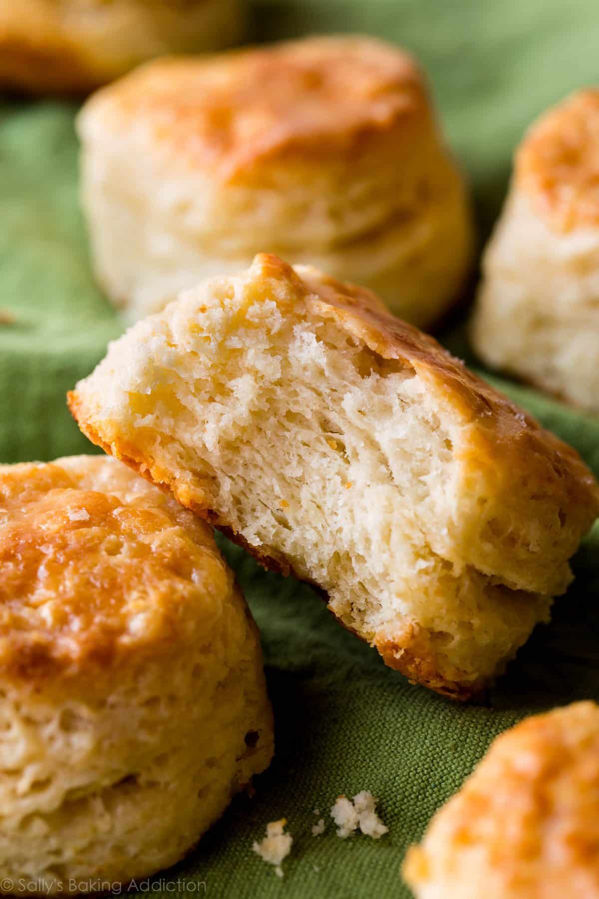 flaky homemade biscuits with a bite out of one showing the layers