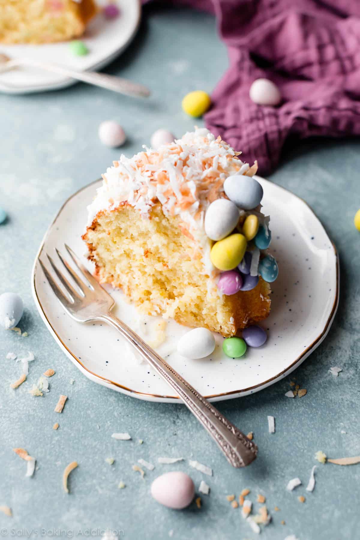 slice of coconut easter nest bundt cake with Easter candy on plate