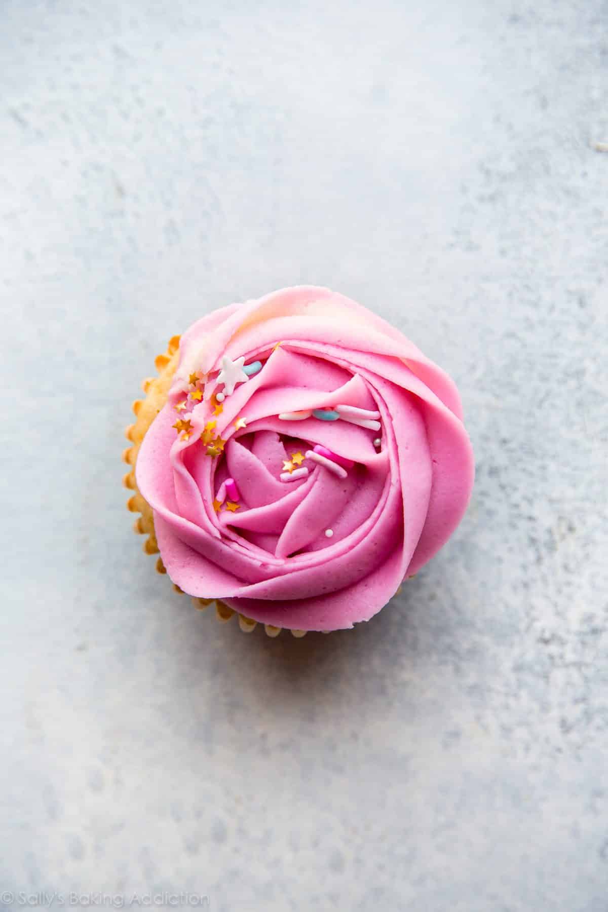 overhead image of cupcake with pink frosting rose on top
