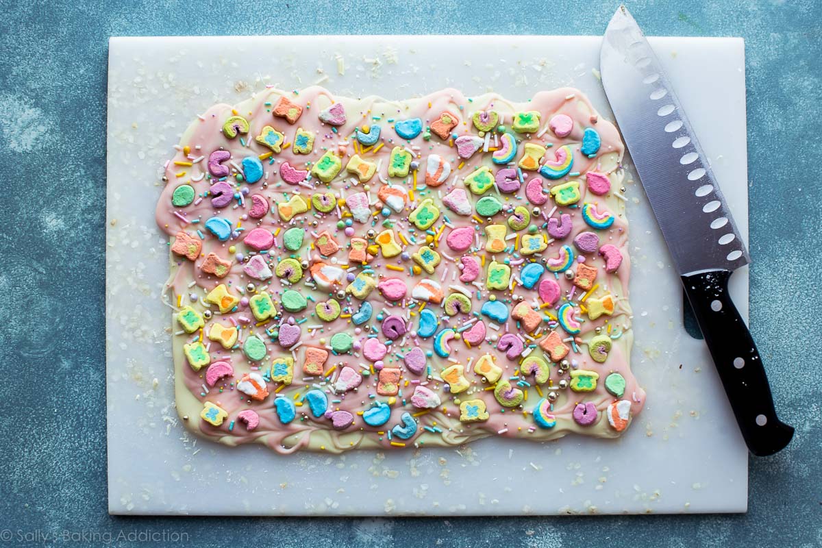 Lucky Charms bark on a white cutting board with a knife
