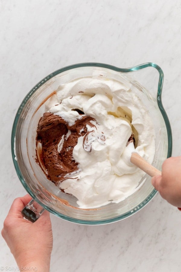 folding whipped cream into chocolate mousse mixture.