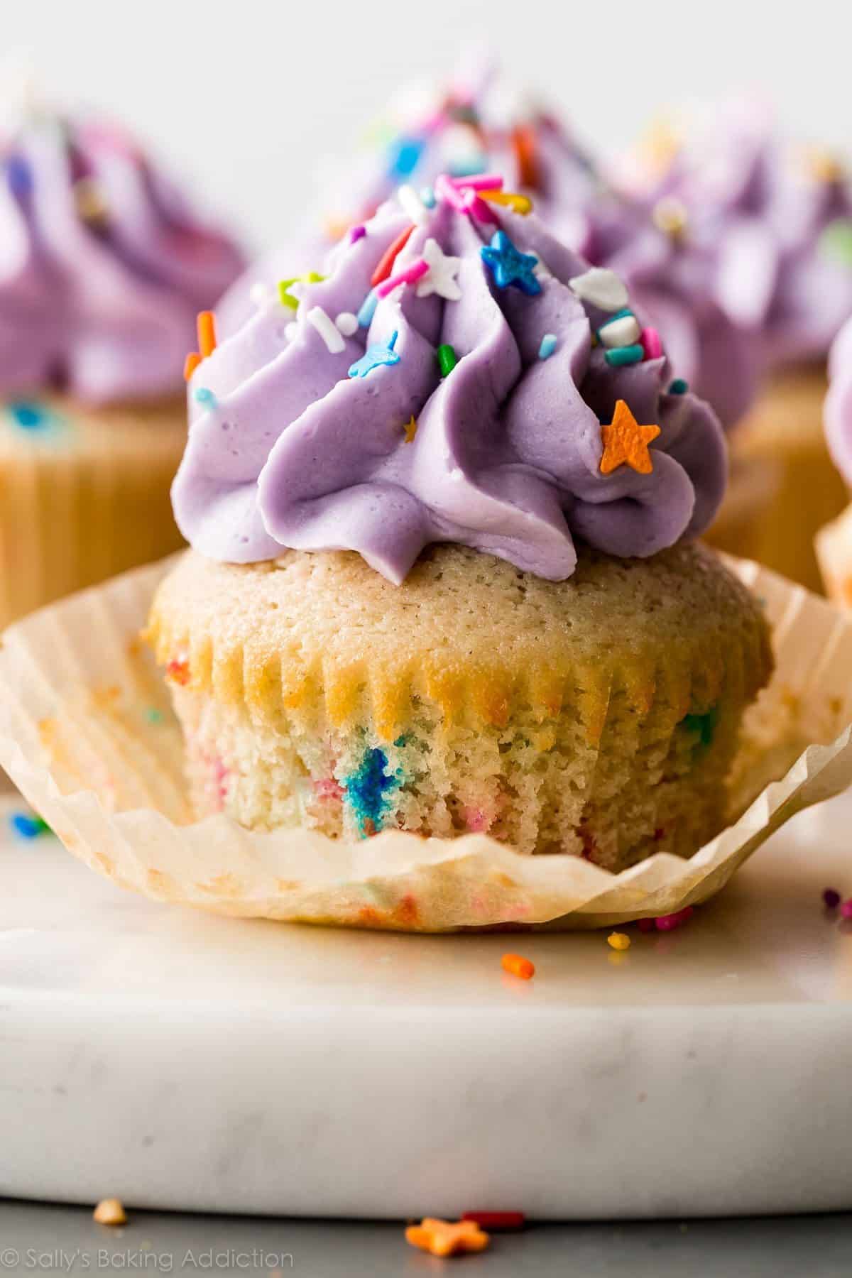 funfetti cupcake with purple frosting and sprinkles