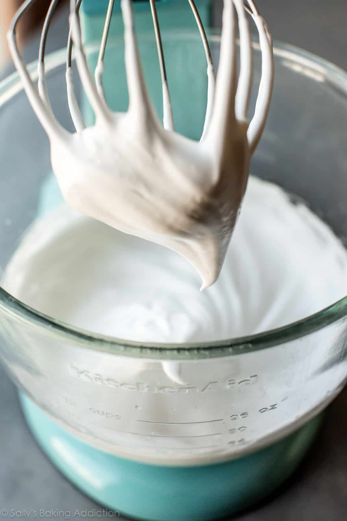 whipped egg whites in a glass stand mixer bowl with a whisk attachment