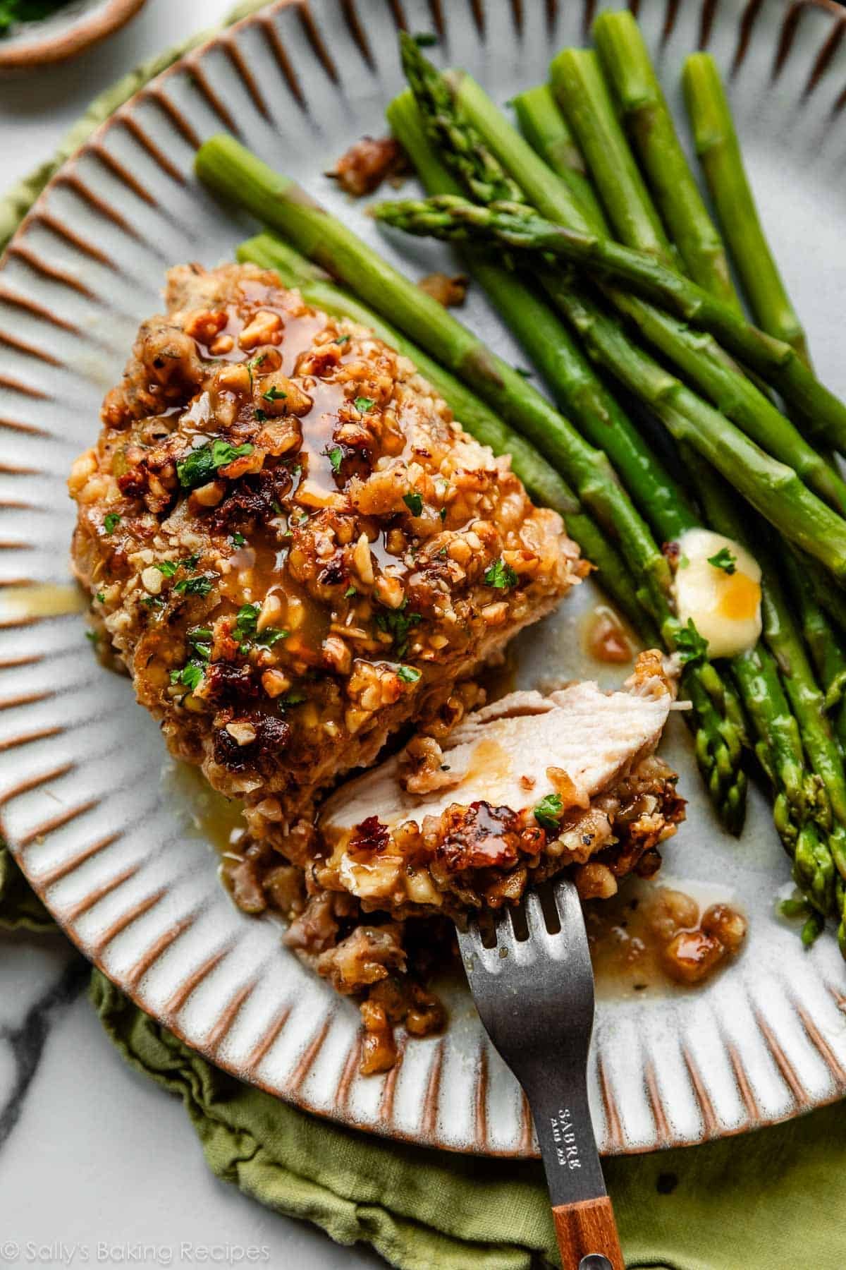 walnut chicken with honey mustard glaze on gray plate with asparagus.