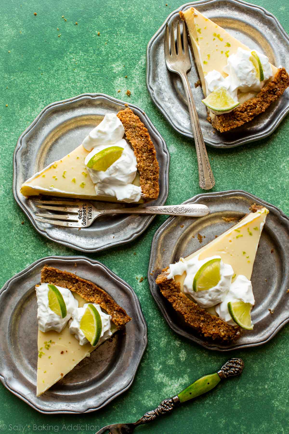 slices of key lime pie on silver plates with forks