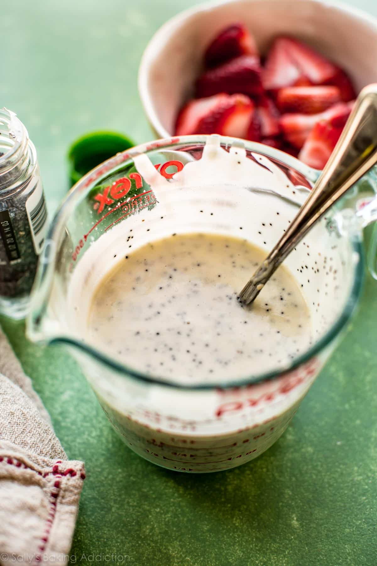 creamy poppy seed dressing in a glass measuring cup