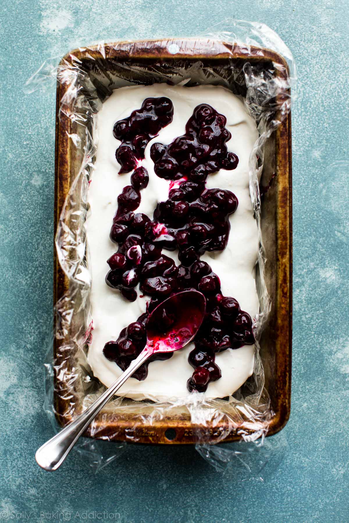 layer of blueberry sauce on top of whipped cream in a loaf pan