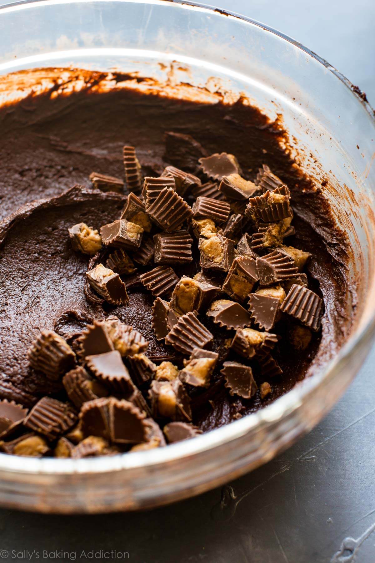 brownie batter in a glass bowl with chopped peanut butter cups