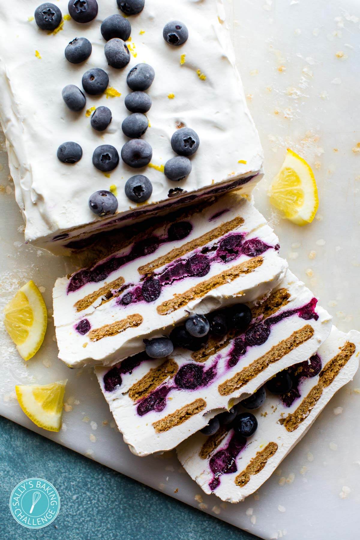 blueberry lemon icebox cake partially sliced onto a white cutting board